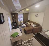 A ház belső tere kanapéval, étkezőasztallal és felszerelt konyhával.