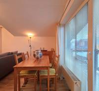 Étkezőasztal öt székkel és lámpával a Nyaraló apartmanban, fa dekor padlóval.