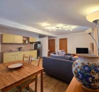 Nappali konyhasarokkal egy üdülő apartmanban, fa dekoros padlóval.