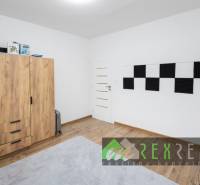 Gyerekszoba fa hatású padlóval és szekrénnyel egy háromszobás lakásban.