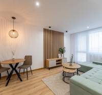 Nappali egy kétszobás lakásban, fa mintázatú padlóval, kényelmes kanapéval és asztallal.