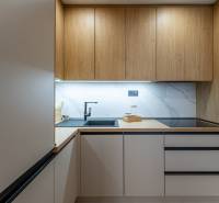 Konyha fa mintázatú padlóval és beépített készülékekkel egy kétszobás lakásban.