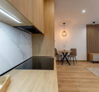 Konyha egy 2 szobás lakásban fa dekoros munkalappal és padlóval.