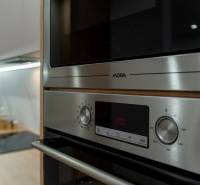 Konyhabútor egy háromszobás lakásban rozsdamentes acél sütővel és mikrohullámú sütővel.