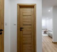 3 szobás lakás belső tere fa dekor padlóval és fa ajtókkal.