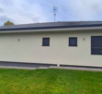 Családi ház Studienkában terasszal, zöld gyepes udvarral és modern homlokzattal.