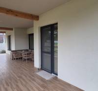 A Studienkában található családi ház terasza hintával és bútorokkal, fa dekorációjú padlóval.