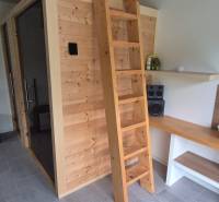 Családi ház belső tere fa szaunával, létrával és sztereó berendezéssel.