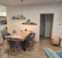 Étkező egy családi házban fa padló dekorációval és hat személyes asztallal.