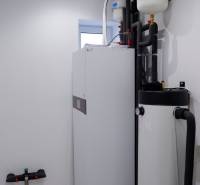 A családi ház fürdőszobájának berendezése bojlerekkel és csövekkel, világos falakkal.