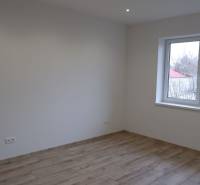 Szoba családi házban fehér falakkal és fa dekorációjú padlóval.