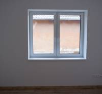 Szoba egy családi házban nagy ablakkal és fa dekorációjú padlóval.