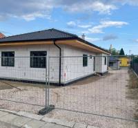 Radaván éppen épül egy családi ház ferde tetővel és fehér homlokzattal.