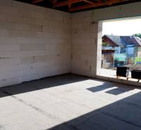 Családi ház építése Radaván, vakolatlan falakkal és környező tájjal.