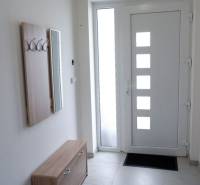 Családi ház előszobája fogassal, tükörrel és dizájnos ajtókkal.