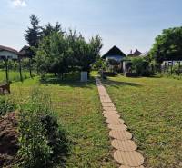 Családi ház kertje Dlhá nad Váhom-ban zöld gyeppel és sétánnyal.