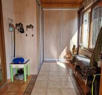 Folyosó csempével, beépített szekrénnyel és paddal a családi házban.