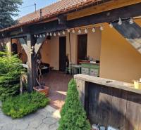 Családi ház Vághosszúfaluban terasszal, fa elemekkel és kerti dekorációval.