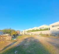 Kilátás a kolárovói családi házakra a hozzájuk tartozó területtel és tiszta kék éggel.