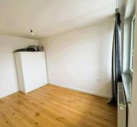 Szoba egy családi házban fehér szekrénnyel és fa dekorációjú padlóval.