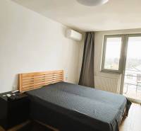 Hálószoba ággyal, éjjeliszekrénnyel és fa dekorációjú padlóval a családi házban.