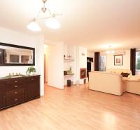 Nappali kandallóval és világos bútorokkal, fa mintázatú padló, családi ház.