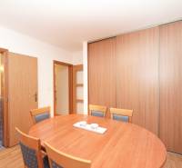 Étkező sarok egy családi házban fa kiegészítőkkel és háttérben fürdőszobával.