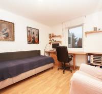 Gyerekszoba családi házban, ággyal, íróasztallal és képekkel a falakon.