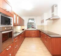 Családi ház konyhája fa dekorációval, főzőlappal és mikrohullámú sütővel.