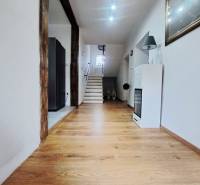 Családi ház belső tere fa dekorációjú padlóval és háttérben lépcsővel.