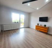 Nappali családi házban fa dekorációjú padlóval, televízióval és komóddal.