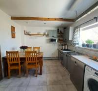 Konyha egy családi házban fa mennyezeti gerendával és sorozat fa székekkel.