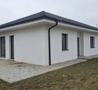 Családi ház Cíferen ferde tetővel és burkolt terasszal a kertben.