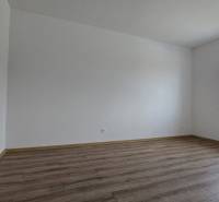 Szoba egy családi házban fa dekor padlóval és nagy ablakkal.