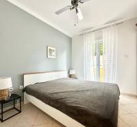 Hálószoba üdülő apartmanban franciaággyal és éjjeliszekrényekkel.