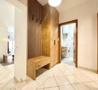 A rekreációs apartman folyosója mosógéppel és fa dekorációjú fogasfallal.