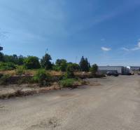 Kereskedelmi telkek a Lučenecká úton Nagykürtösön régi épületekkel és növényekkel.