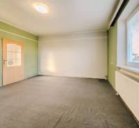 Családi ház belső tere színes falakkal, szőnyeggel és redőnyös ablakkal.