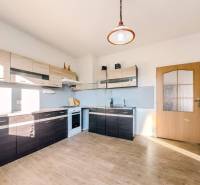 Konyha családi házban fa dekor padlóval és modern konyhabútorokkal.