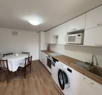 Konyha egy egyszobás lakásban fa dekor padlóval és étkezőasztallal.