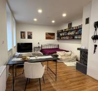 1 szobás lakás belső tere fa dekor padlóval, ággyal és étkezőasztallal.