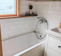 Fürdőszoba családi házban beépített káddal és fehér csempékkel.