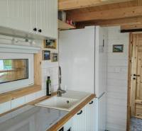 Konyha a családi házban fehér bútorokkal és fa elemekkel.