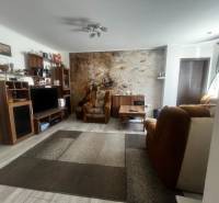 Nappali egy családi házban kényelmes bútorokkal és fa padlódekorációval.