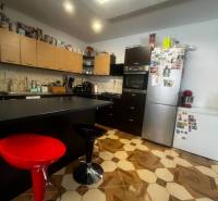 Konyha dekoratív padlóval, konyhabútorral és háztartási gépekkel egy családi házban.