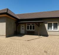 Családi ház Tószegen nyeregtetővel és burkolt udvarral.