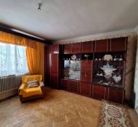 Nappali családi házban, karosszékkel, bútorokkal és fa dekorációjú padlóval.