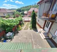 Családi ház külső része Tachtán, kis kerttel és kilátással a dombokra.