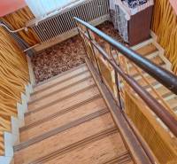 Lépcső szőnyeggel és fa dekor padlóval családi házban.