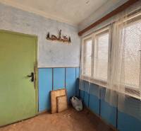 Családi ház belső tere fa dekorációjú padlóval, kék falakkal és zöld ajtókkal.